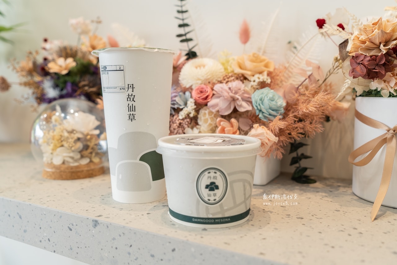 澎湖丹故仙草(菜單)好吃嗎?在地推薦的澎湖仙草冰! - 第6張圖 丹故仙草外帶,拿著仙草凍在文青背景前拍照